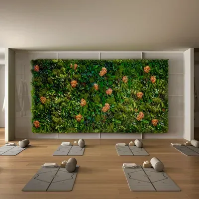 Movement studio with a large botanical moss wall above wooden floors and yoga mats